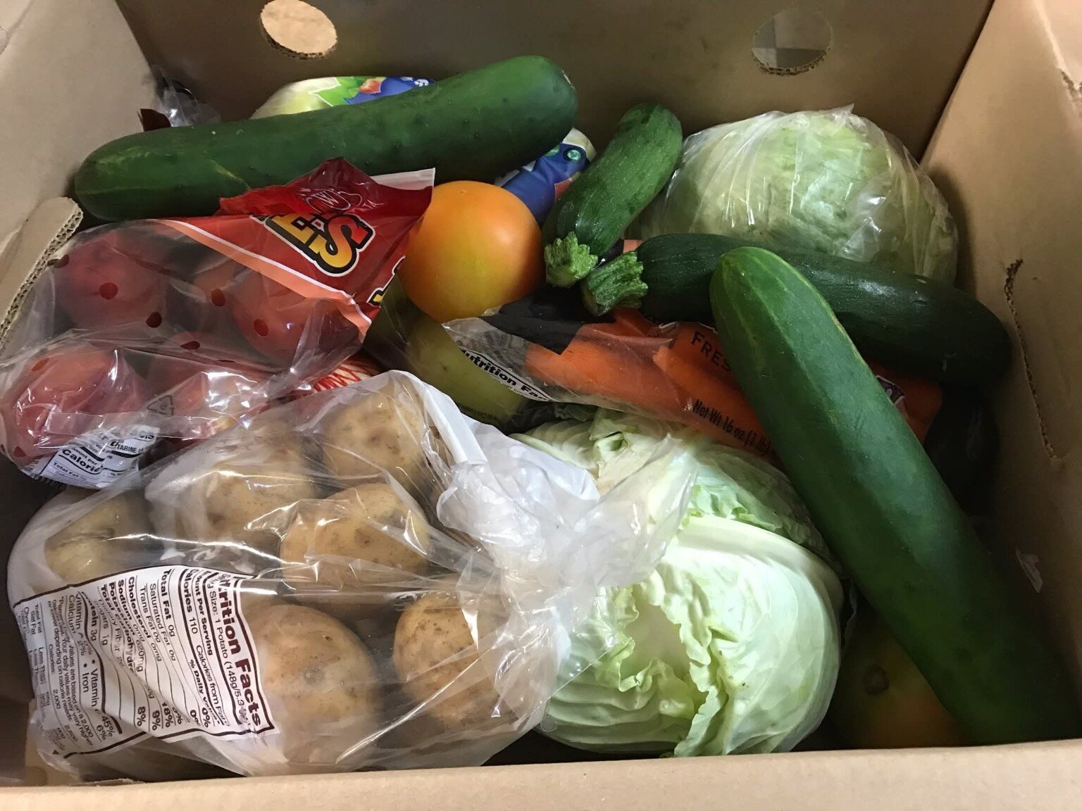 A box filled with fresh vegetables for food distribution